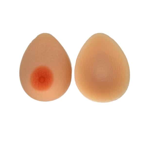 A pair of silicone breast forms, light flesh colored with realistic nipples. One is turned so you can see the concave back.